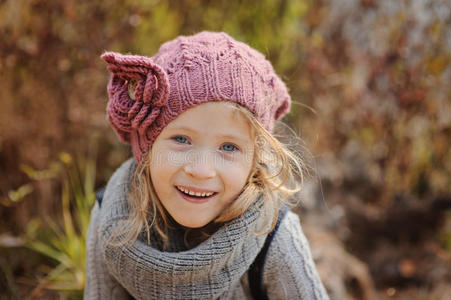 可爱快乐的小女孩，戴着针织帽子，戴着斯努德肖像在秋天