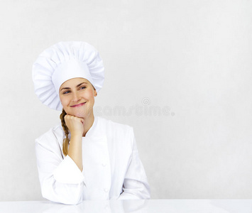 厨师想着，面带微笑，开心地站在一旁。女厨师，厨师或面包师，穿着厨师制服和帽子。