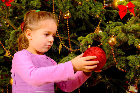 可爱的小女孩拿着装饰性的圣诞玩具球