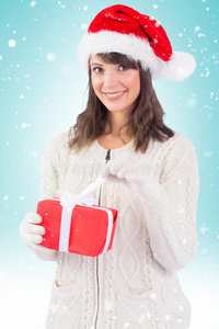 戴圣诞帽微笑的年轻女子打开礼物的合成图像