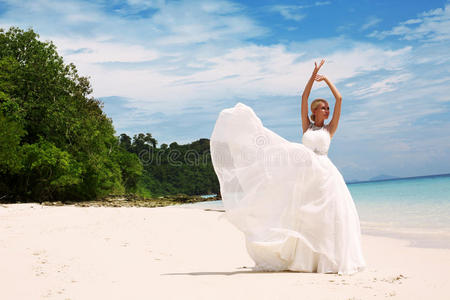 美丽的新娘穿着优雅的婚纱在泰国的海滩上摆姿势