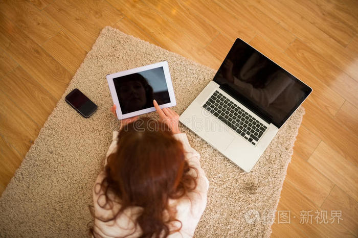 躺在地上的漂亮女人在chritmas使用技术