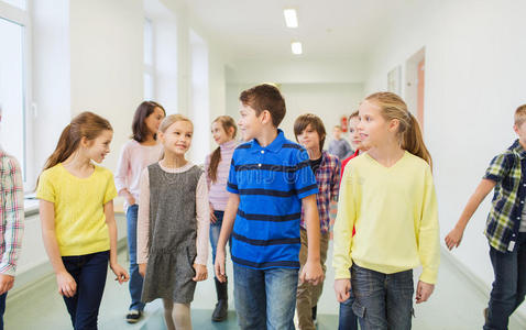 一群微笑的学童走在走廊里