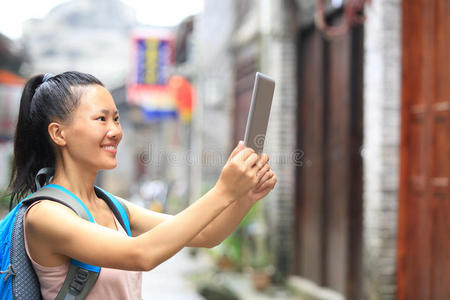 亚洲年轻女子用数码平板拍照
