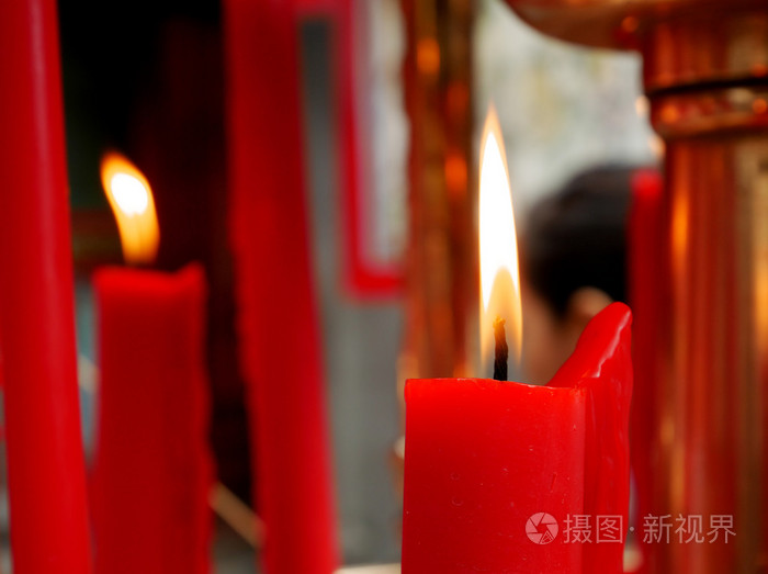 在华人庙宇的红蜡烛上的火焰