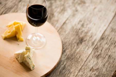 奶酪和红酒在托盘上的玻璃