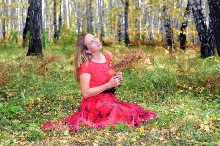 在秋天的树林里穿红色衣服的美丽女人