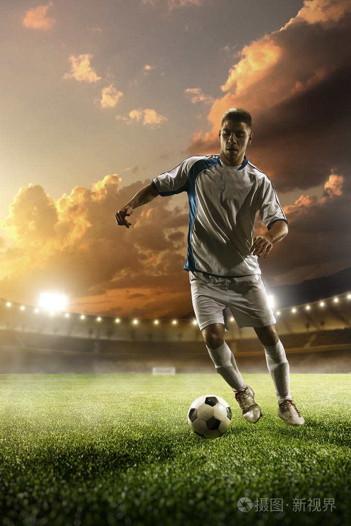 足球运动员在行动上日落体育场背景照片-正版商用图片1l619y-摄图新