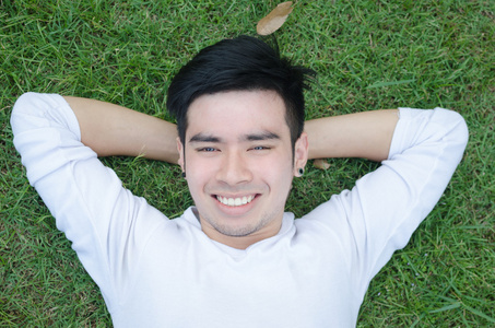 一个年轻人快乐放松他汉与草地上的肖像