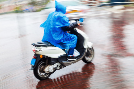 摩托车手与雨披风运动模糊