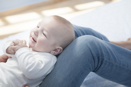 年轻的母亲喂奶乳房后玩她的宝宝