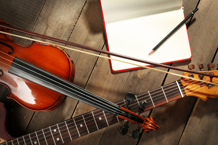 电吉他 小提琴 女高音萨克斯管和木制背景上的书