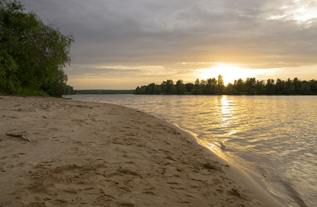 海滩在河上与树木的日落