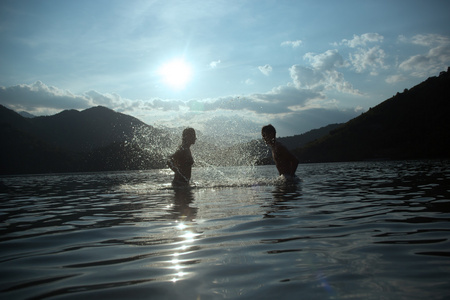 Silhoueted 对年轻夫妇在海滩上 dus 烟霞夏天天