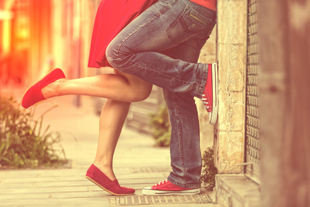 年轻夫妇接吻室外。男性和女性的双腿。跨过程