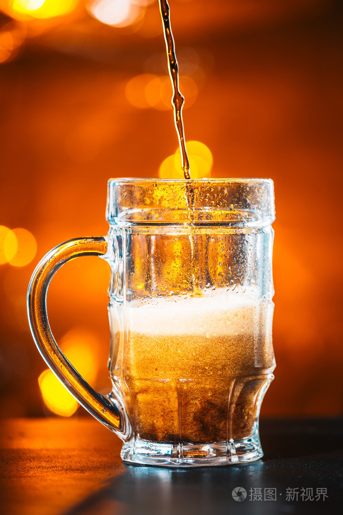黑暗的啤酒倒进一个玻璃杯子