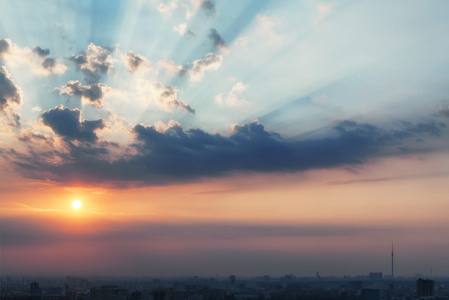 与太阳光线的日落。多彩的模糊天空与太阳背景。在城市上空的日落，日出