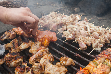 男子手把 bbq 鸡翅在火盆