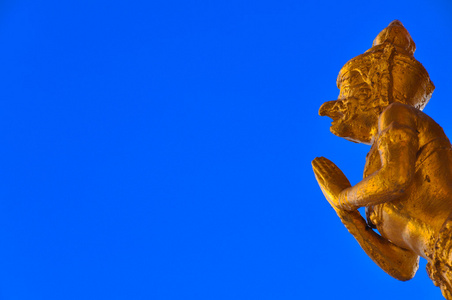 蓝色背景的金色揭路荼雕像图片