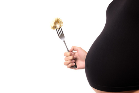 怀孕的女人在吃花椰菜