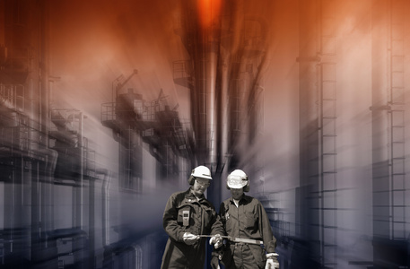 石油工人和大型炼油厂在背景中图片