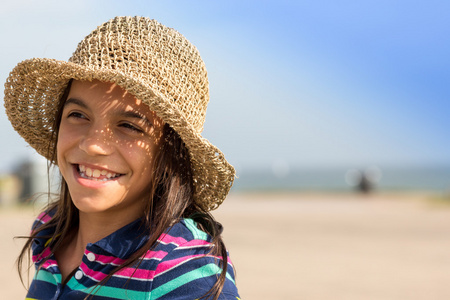 年轻的姑娘戴着帽子的海滩