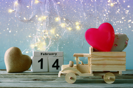 2 月 14 日的照片木制老式日历与木制玩具卡车用黑板前面的心。情人节那天庆祝概念。老式过滤