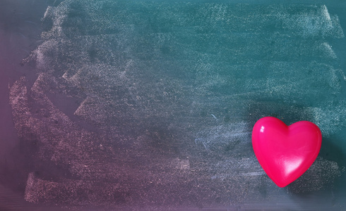 黑板背景上粉红色塑料心脏的俯视图像。 v.