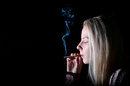 戴着太阳眼镜,抽着烟斗女孩和家伙的技工在工作服装坐在修理车库附近