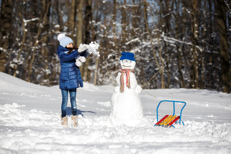 小女孩玩堆雪人