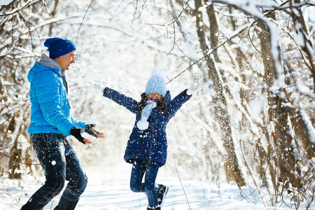 父亲和女儿在冬天玩雪