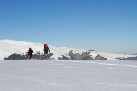 在山里徒步旅行带着背包和帐篷雪的冬天