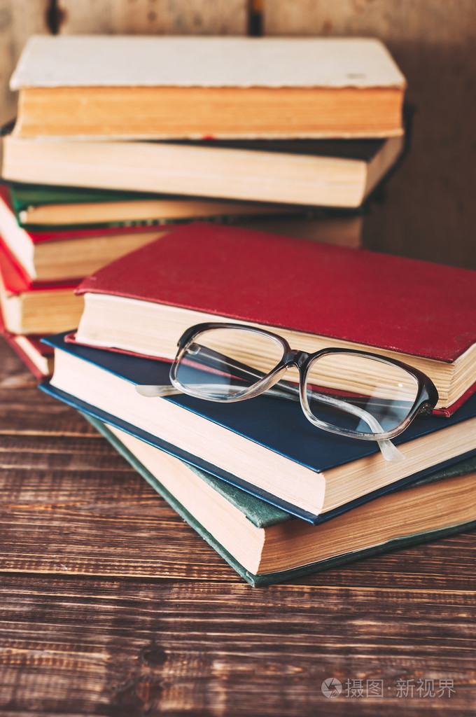 旧的书和眼镜木制棕色的桌子上.顶的视图