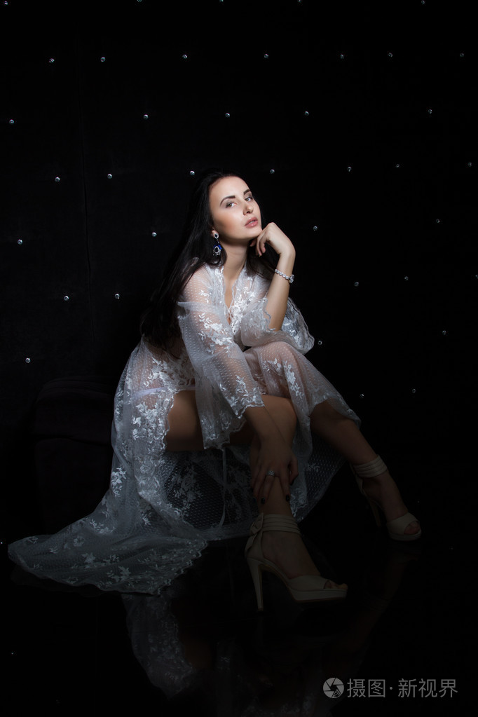 一个年轻的女子,在黑色背景上的花边闲荡的肖像