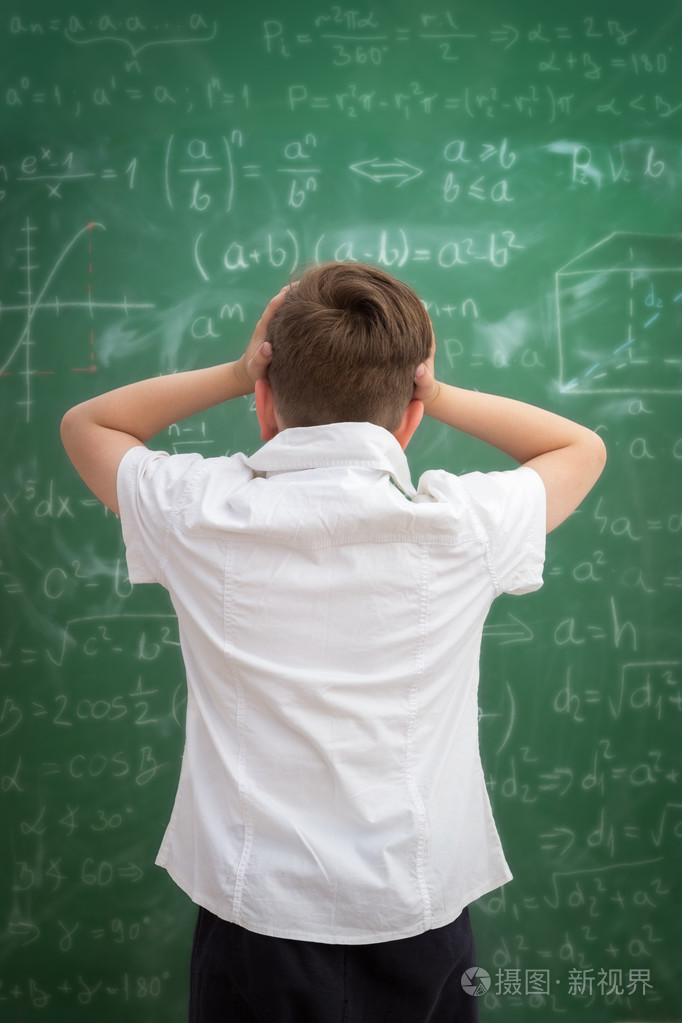 不安的孩子看着黑板上的公式完全