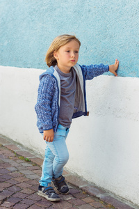 室外肖像的可爱的小男孩，身穿蓝色针织的外套
