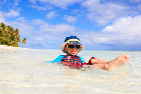 可爱的小男孩在热带的海滩上放松