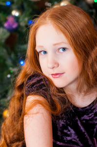 美丽的女孩在圣诞节树附近