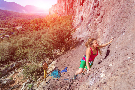 年轻美丽的女性攀岩者攀登岩壁