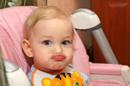 一个金发小孩用微翘的嘴唇的肖像