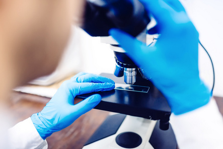 科学家使用显微镜对考试小化学探测器。医疗设备和实验室样品