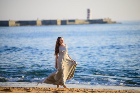 幸福的女人享受海滩日落