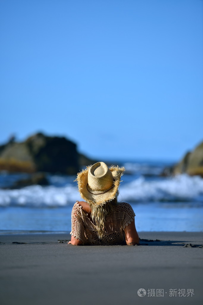 年轻女子坐在沙滩上照片-正版商用图片1lcevi-摄图新视界
