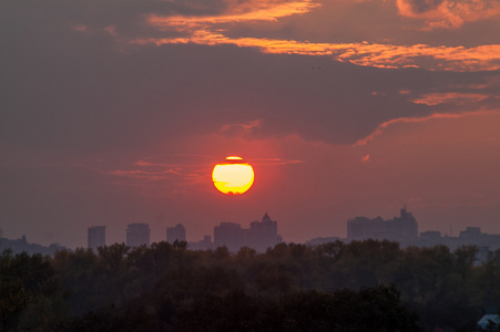 日落时的太阳, 城市上空有云