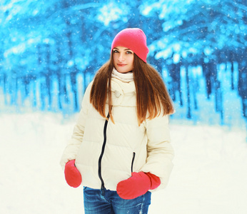 美丽的年轻女子走在冬季森林在雪