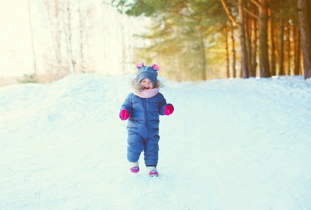 性格开朗小孩子玩在冬季森林的雪地上
