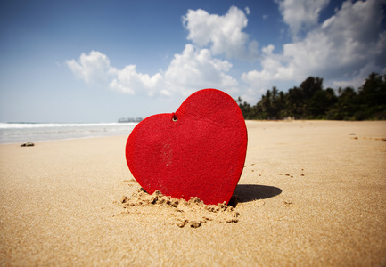 红色的心，在异国的沙滩情人节概念