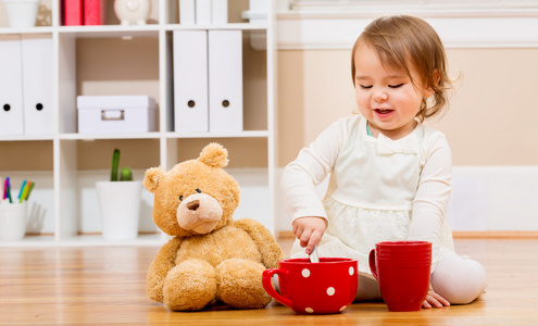 女孩有茶的时间与她的玩具熊图片