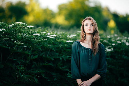 美丽的年轻女子假扮开花春天公园里