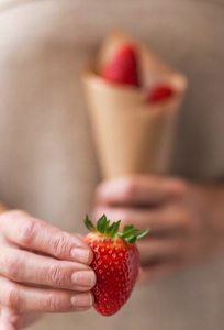 手拿着美味的草莓的特写镜头